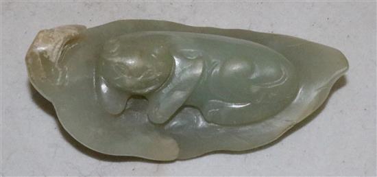 A Chinese celadon jade carving of a recumbent cat on a leaf, 18th / 19th century,